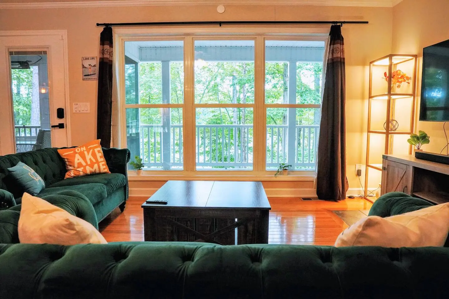 A pair of accent chairs beside a wall of windows looking into the trees