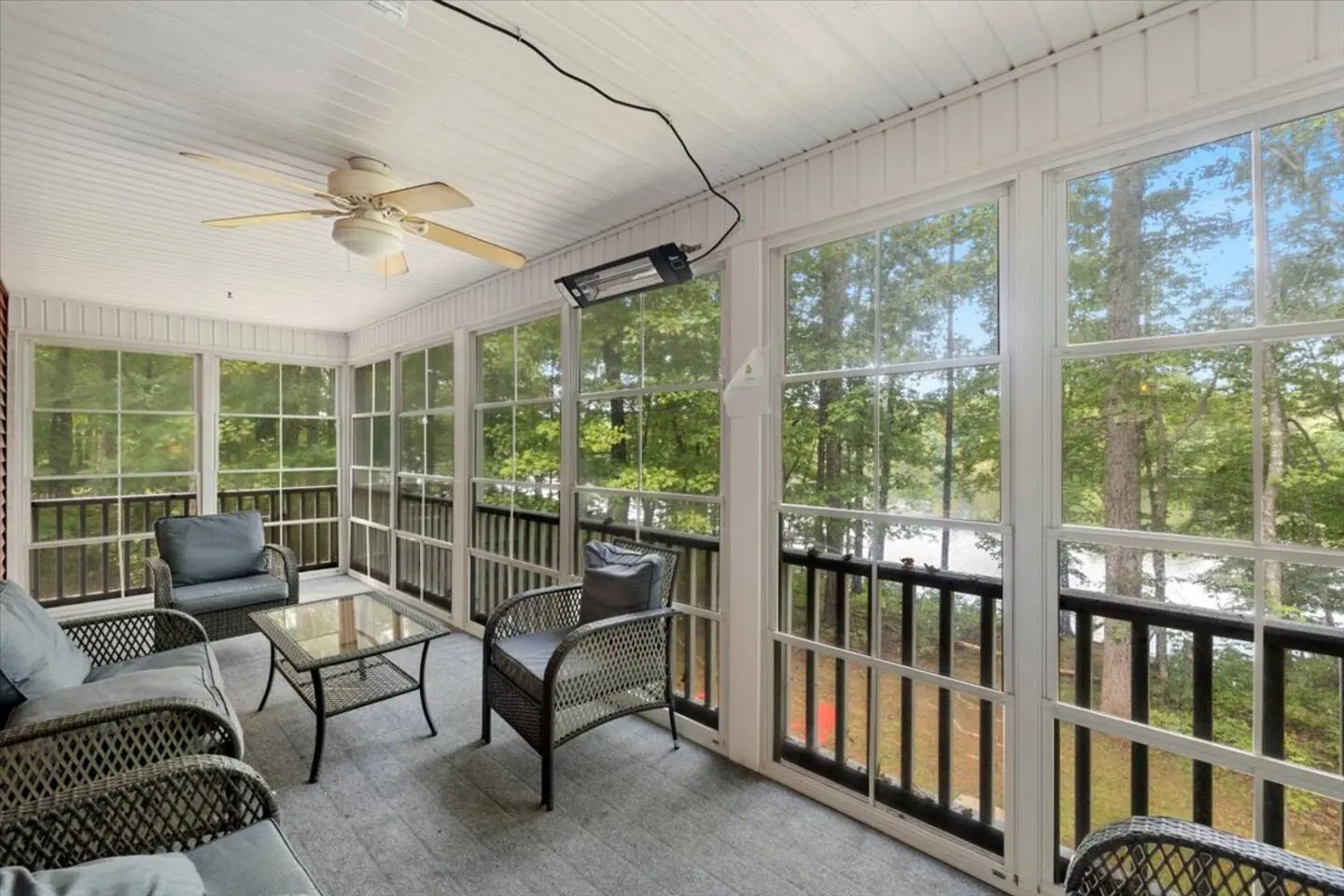 Bright screened porch with seating, looking out into the woods