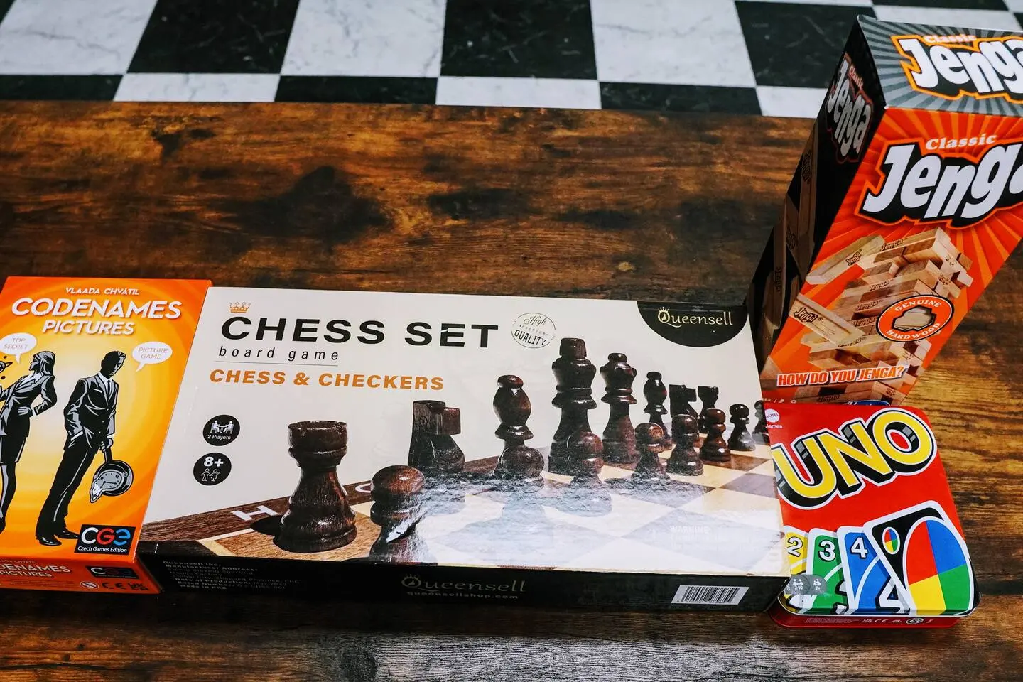 Stack of board games — chess, Jenga, Uno, and Codenames