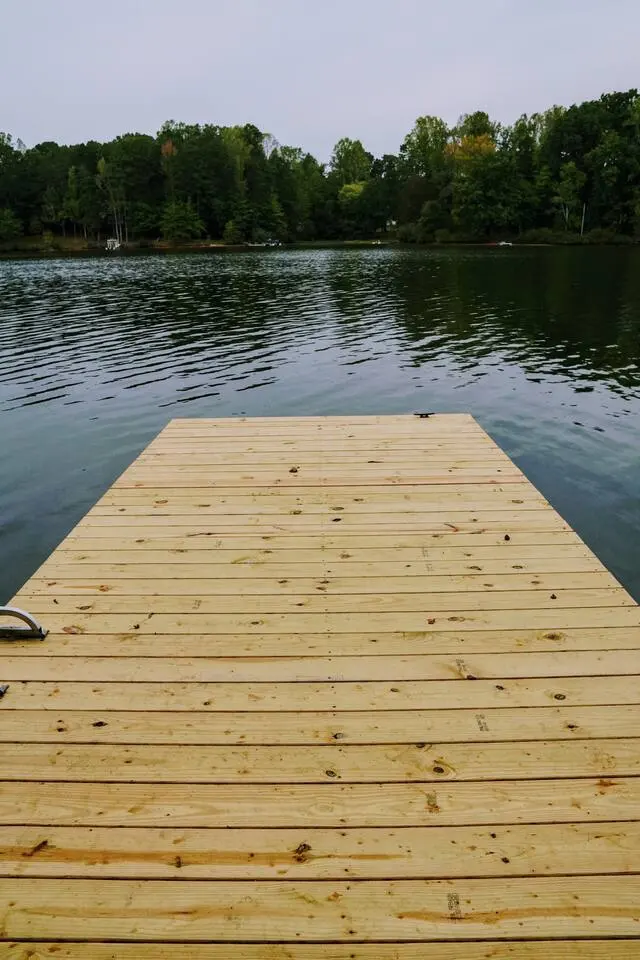 Fresh light-wood boards of the private dock reaching into Mayo Lake