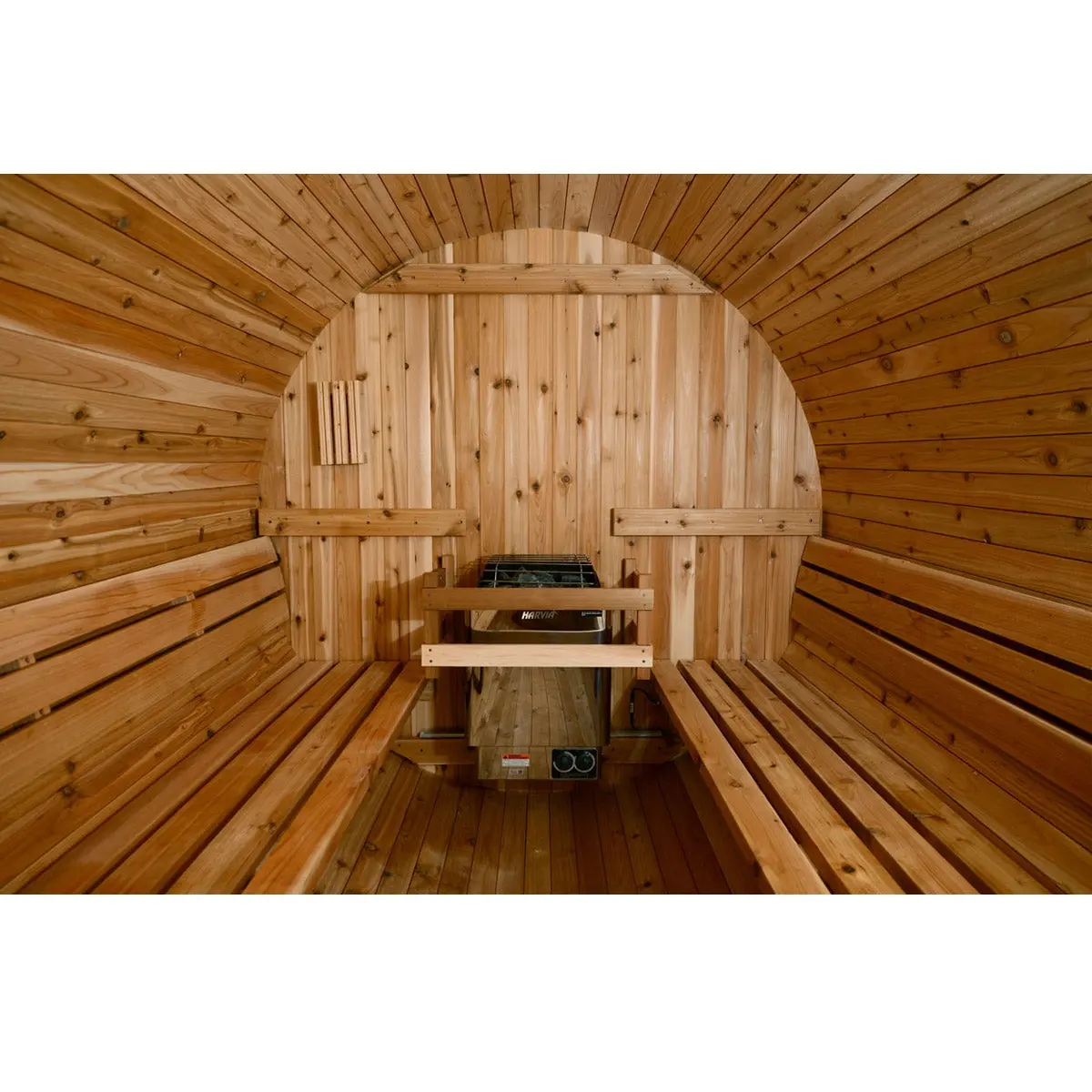 Interior of the cedar barrel sauna with two facing benches and a Harvia heater